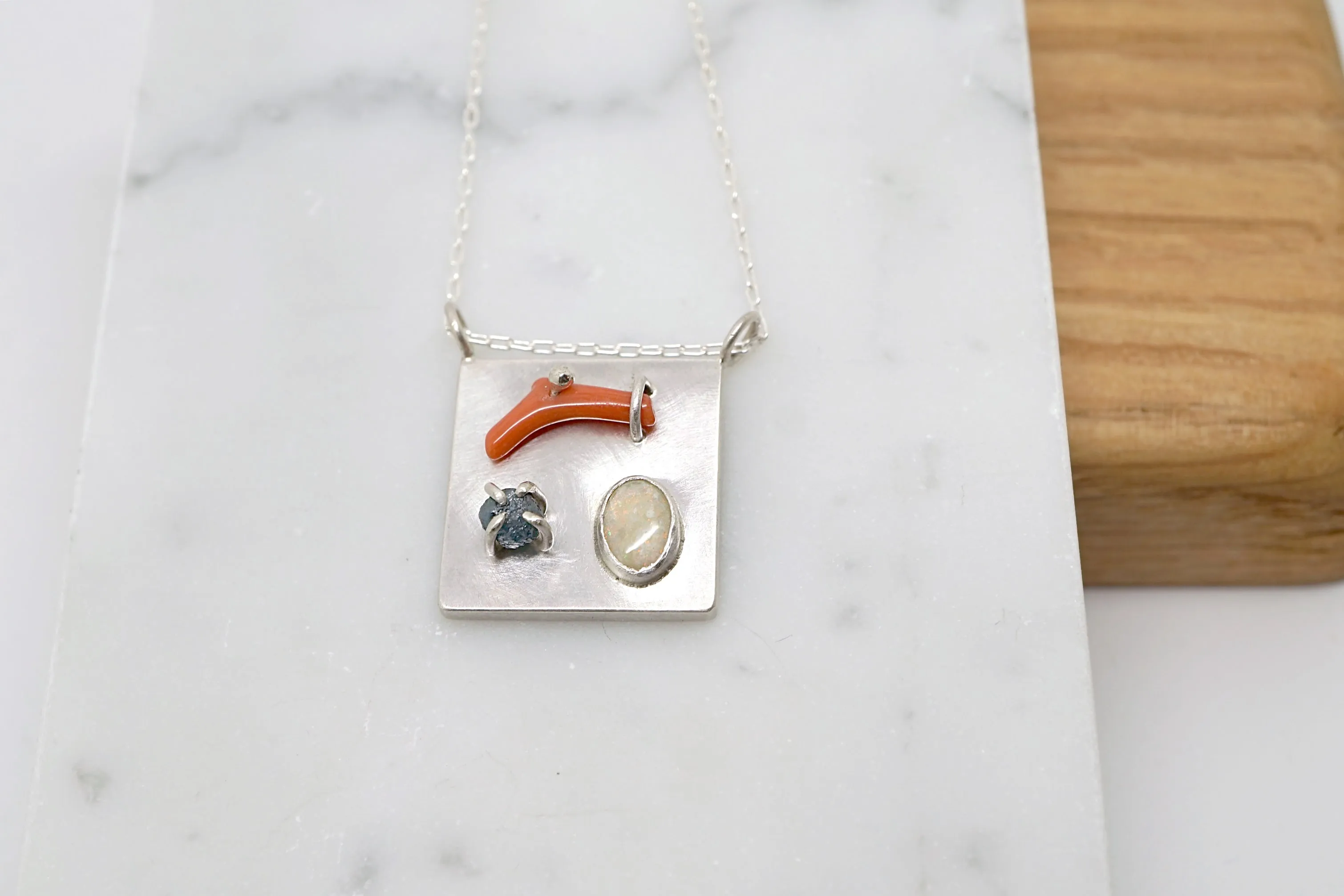 Art pendant necklace with coral, opal, and raw diamond